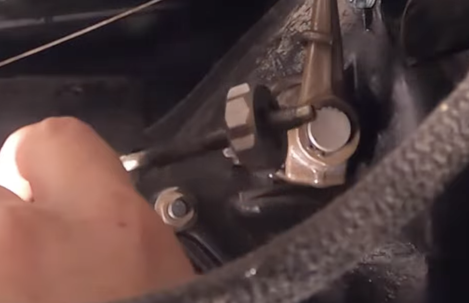 Cleaning the clutch cable threads with a wire brush