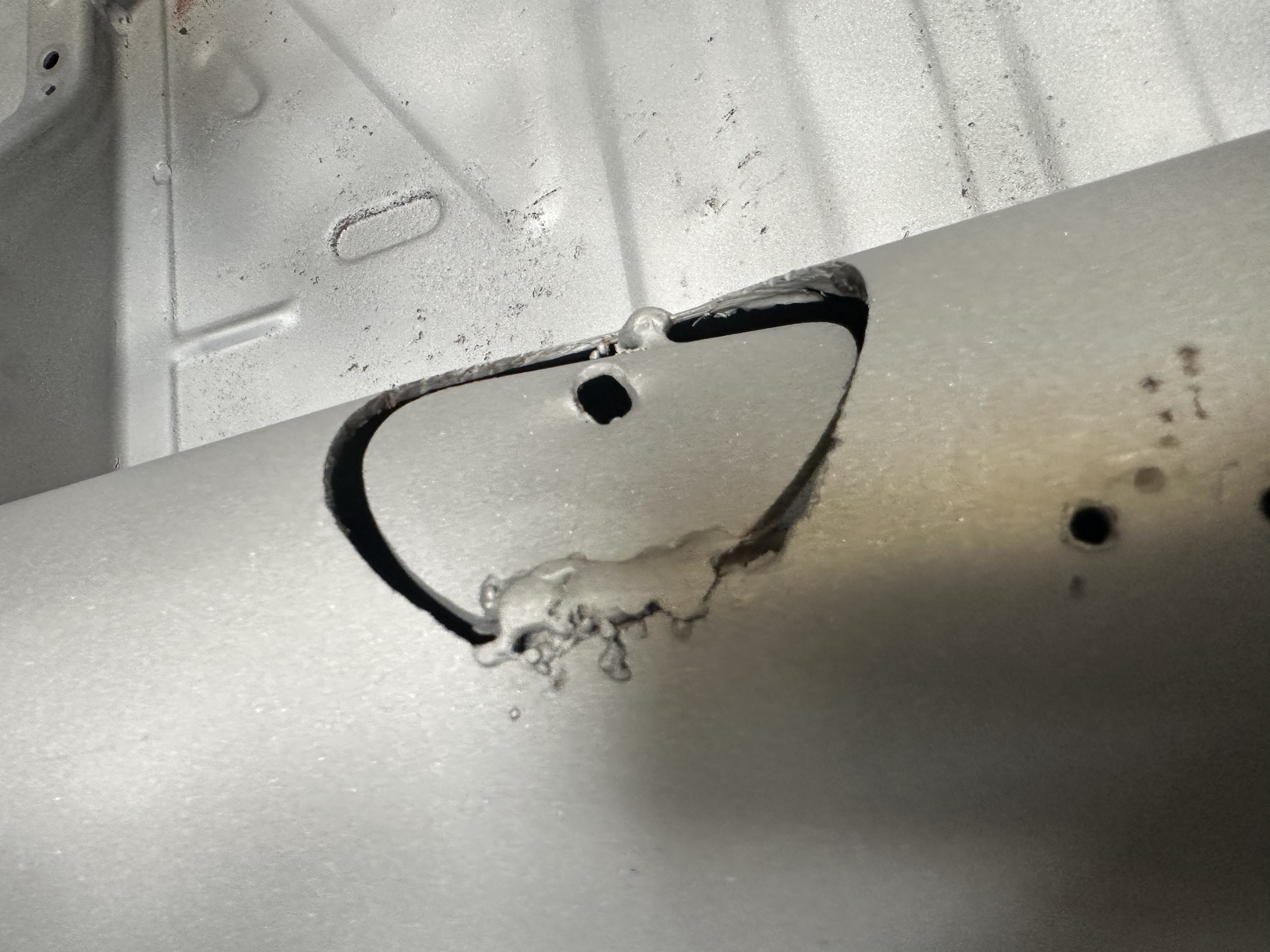 Old hole-saw fix to the chassis tunnel, hammered flat and hidden under carpet