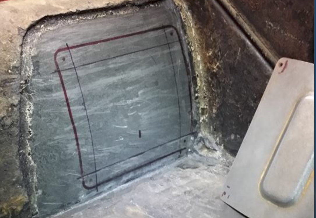 Marking the cutout rectangle on the chassis tunnel with a Sharpie