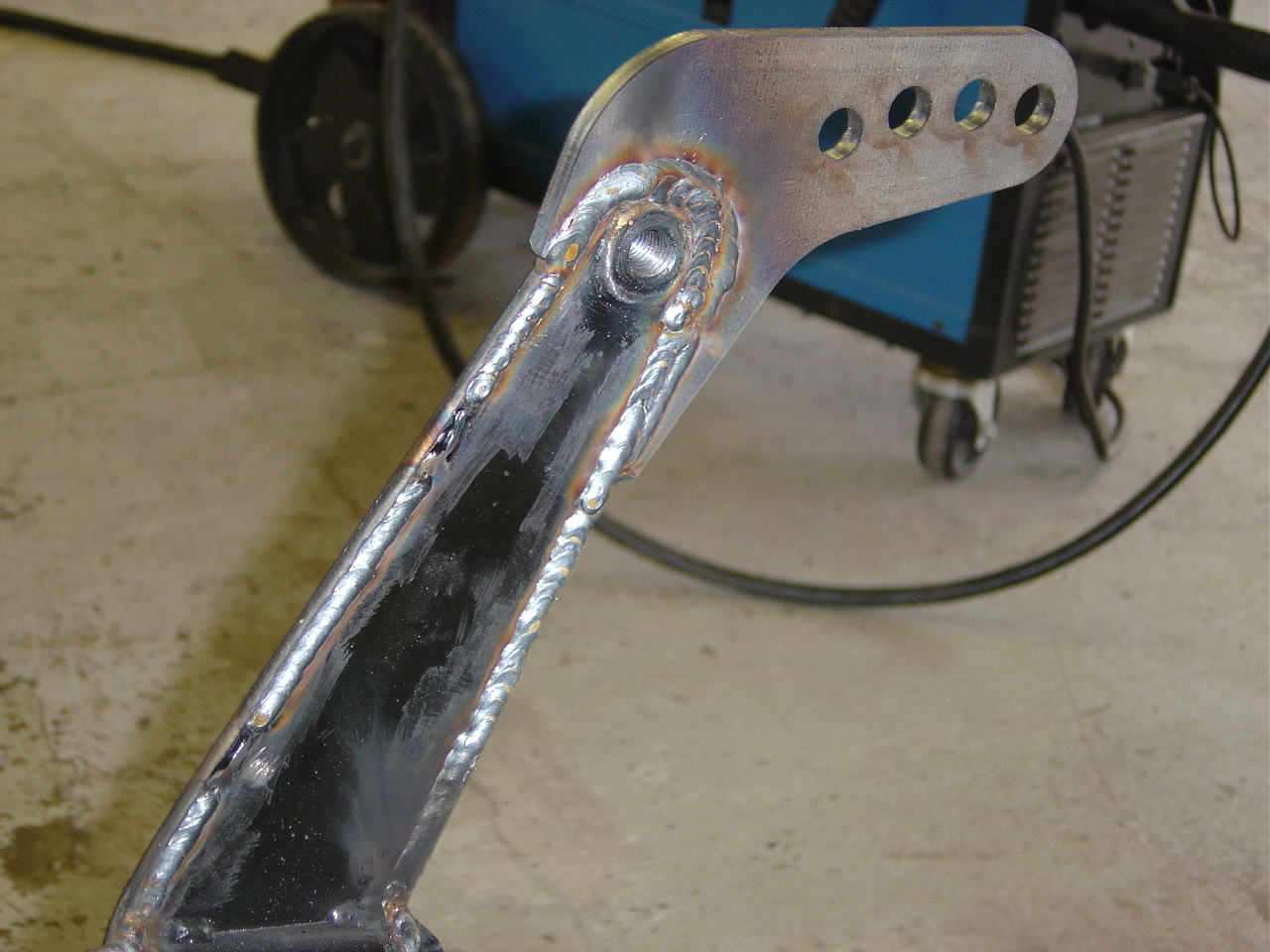 Upper shock mount tack-welded to the link-pin beam, ready to cycle and verify clearance
